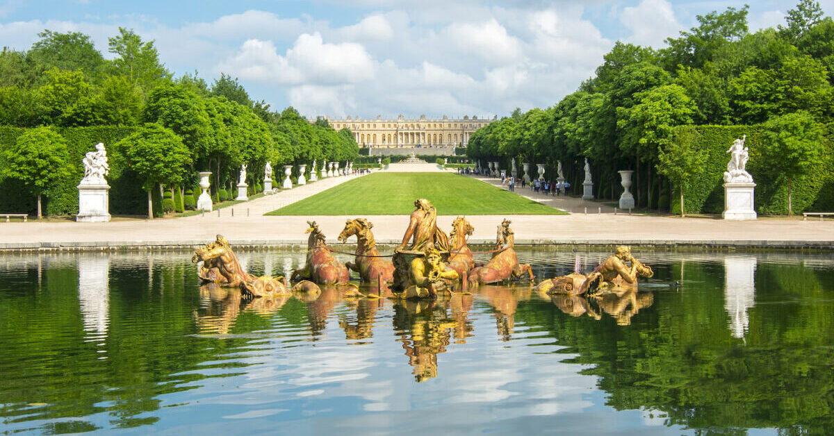 A group of people standing next to a body of water surrounded by trees