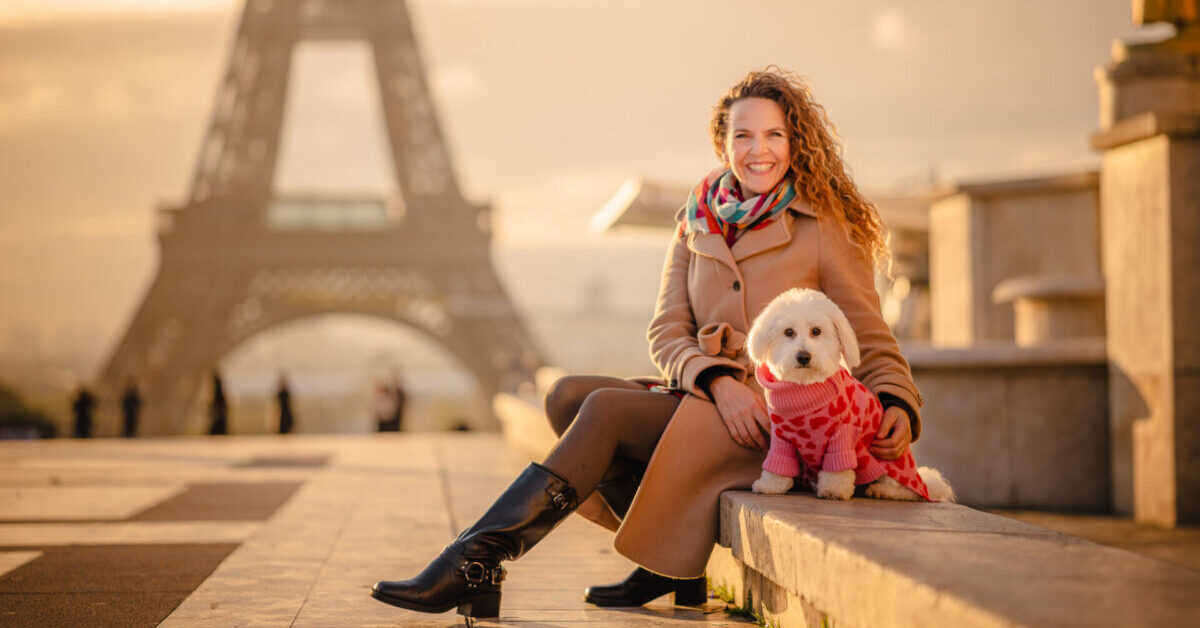 Woman with dog in front of Eiffel Tower.
