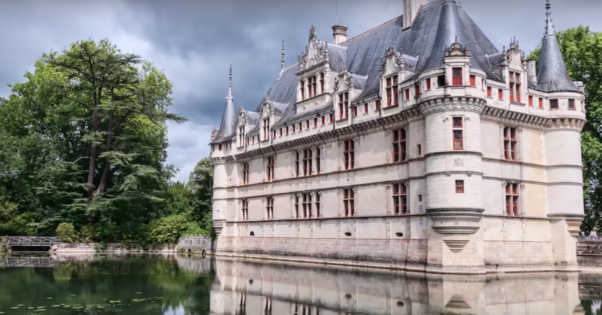 A castle with a boat in the water with Château d'Azay-le-Rideau in the background