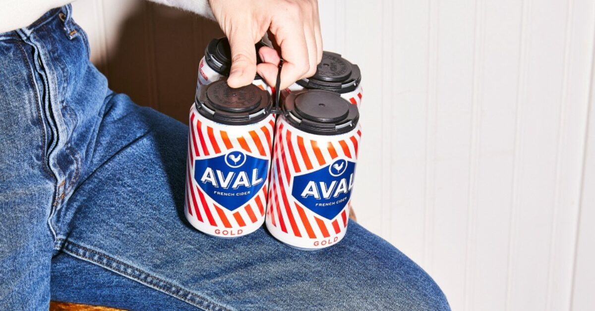 Person holding four pack of Aval cider on jean leg