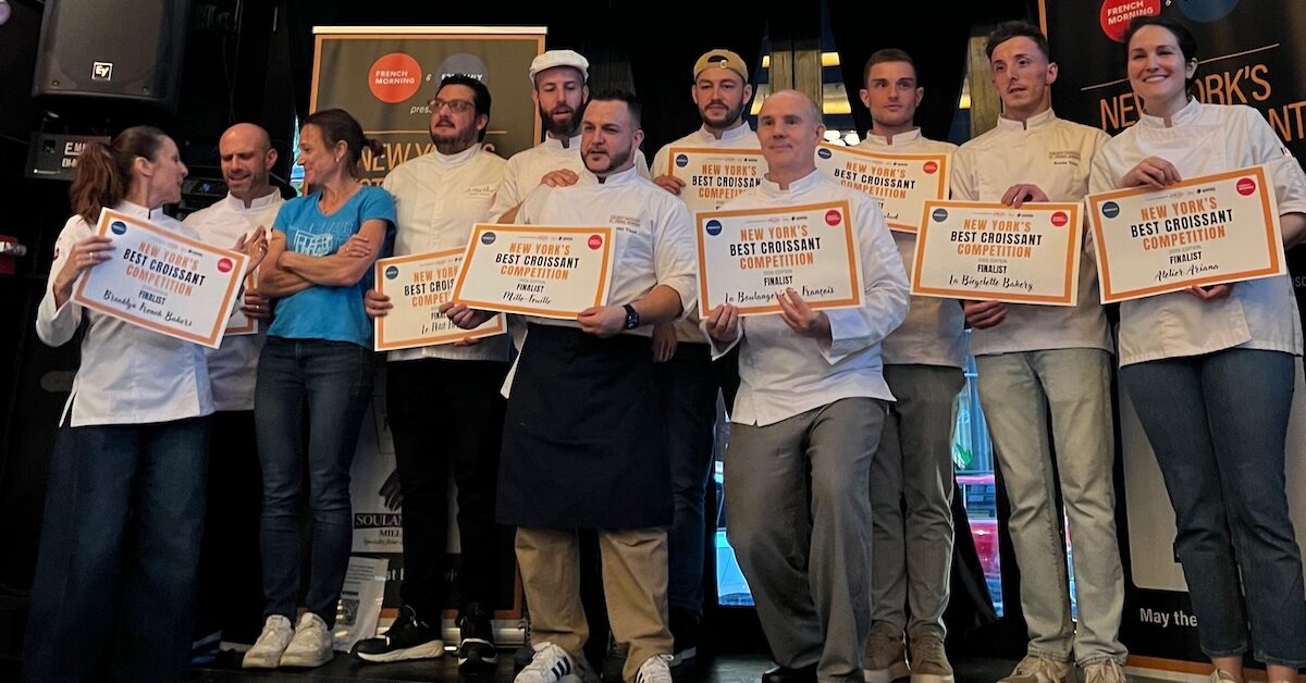 Winners of the Best Croissant Competition standing on a stage in chef's whites.