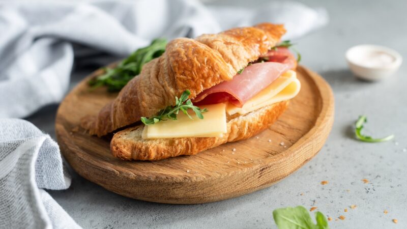 Sandwich with ham and cheese on croissant bun.