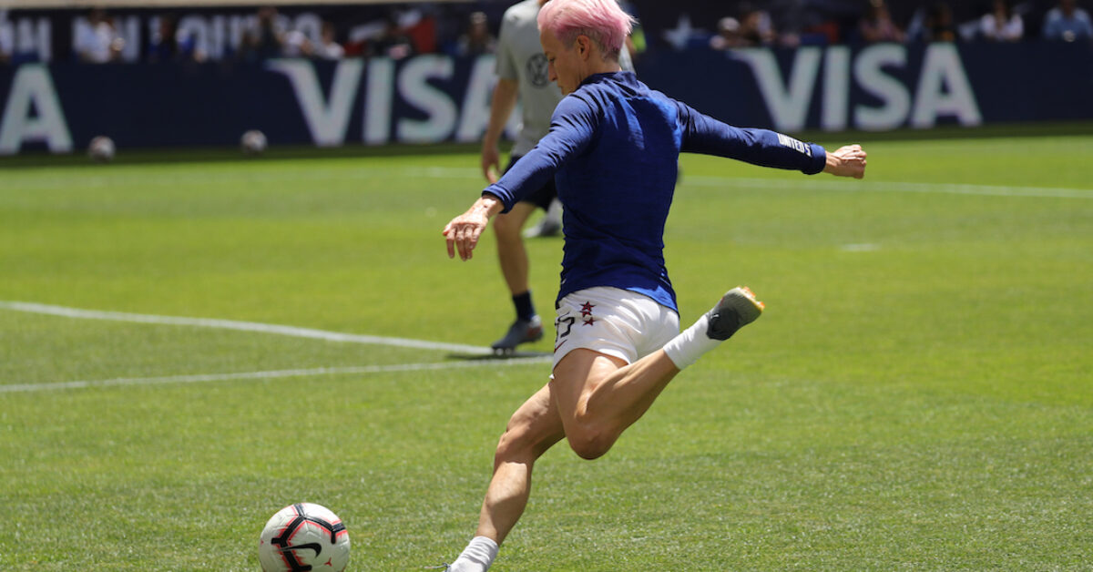 A football player kicking a football ball on a field