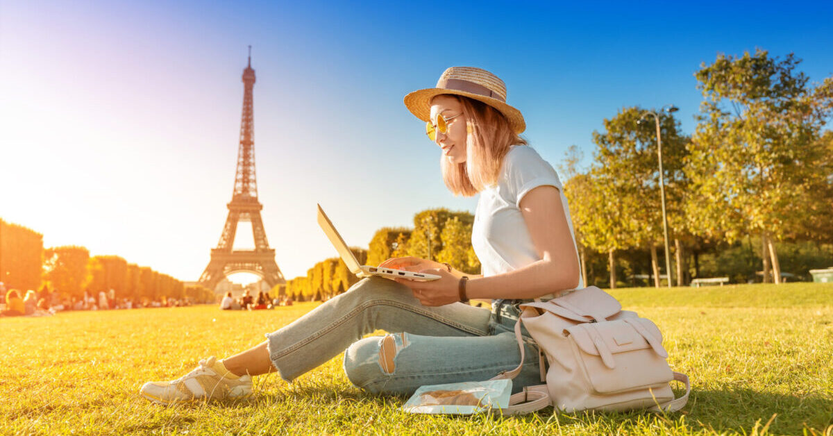 An,Asian,Girl,Works,On,A,Laptop,Sitting,On,The