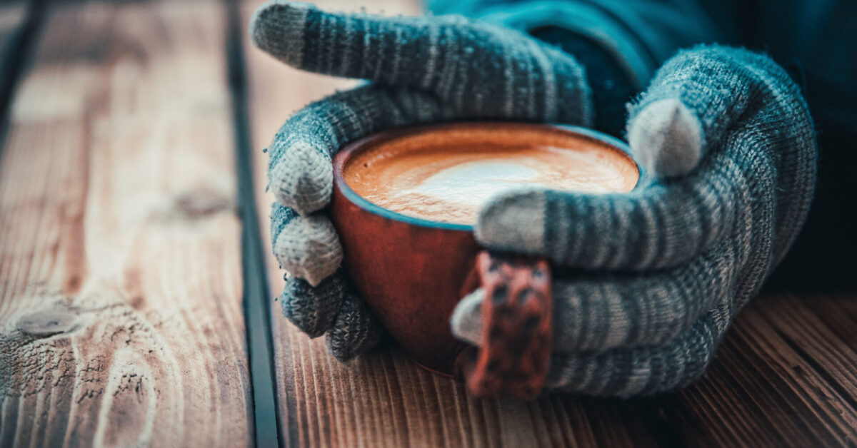 Female,Hands,In,Gloves,Hold,A,Cup,Of,Hot,Cappuccino