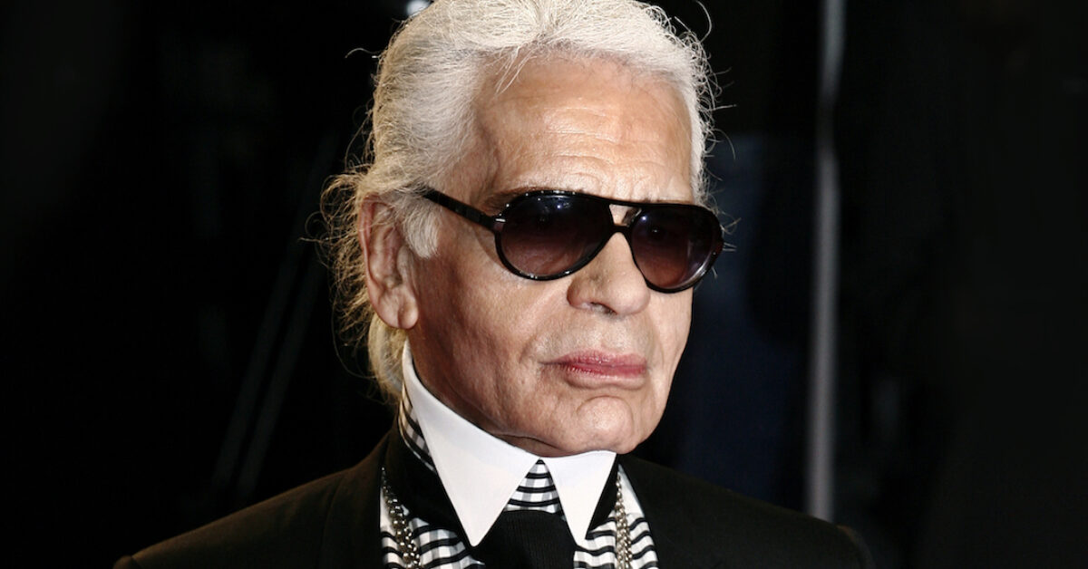 A person wearing a suit and sunglasses posing for the camera