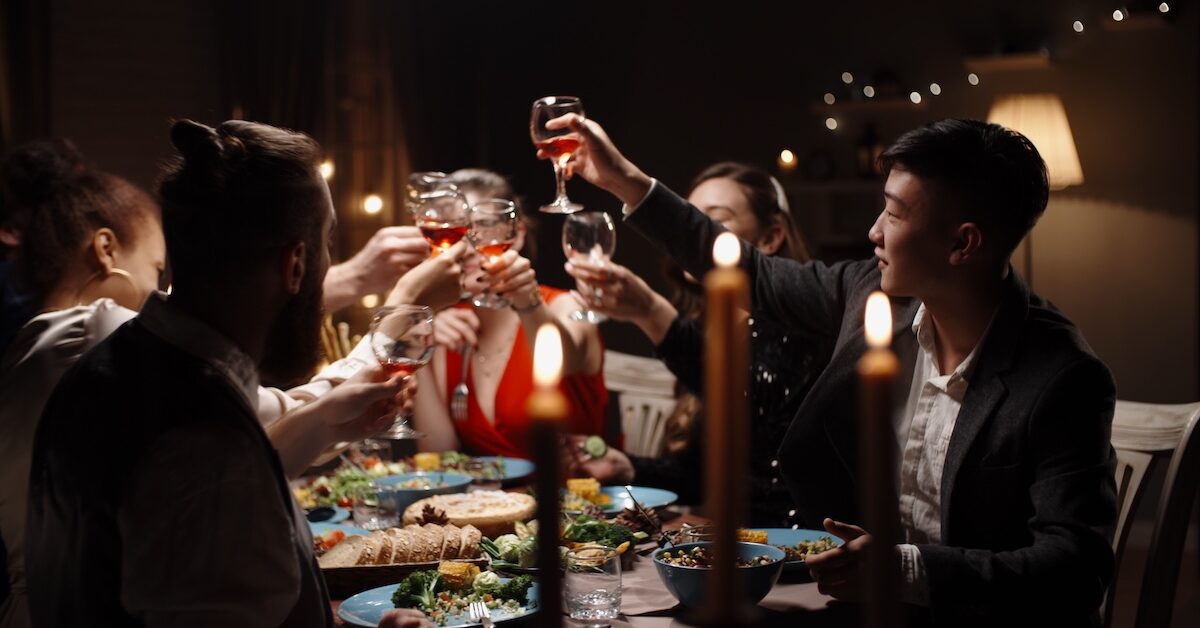 Group of friends toasting at a candlelit dinner party.