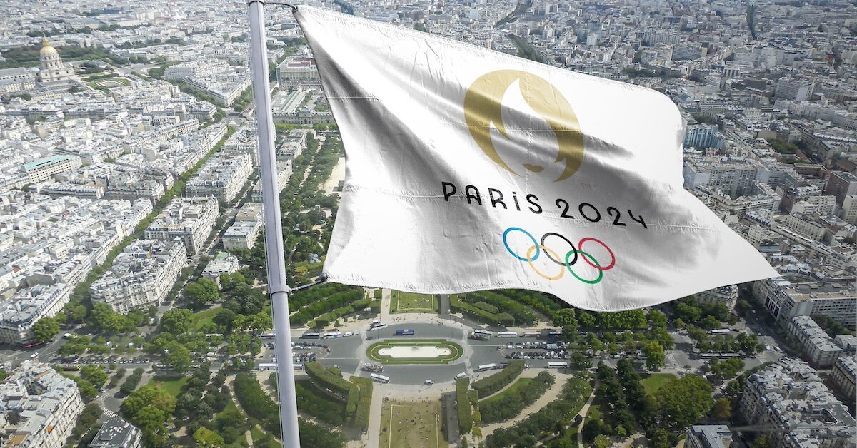Paris 2024 flag flying over the city.