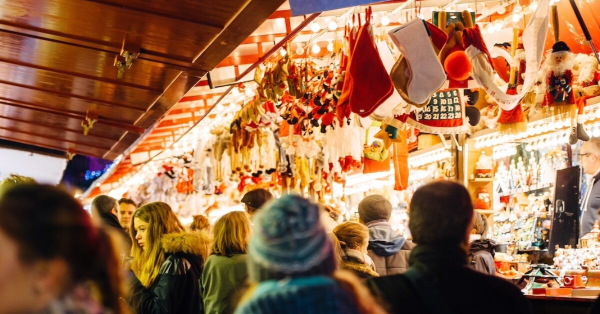 STRASBOURG, FRANCE - NOV 28, 2015: Busy Christmas Market Christkindlmarkt in the city of Strasbourg, Alsace region, France with people admiring Christmas gifts