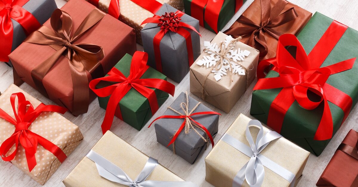 Lots of Gift boxes on white background. Presents in craft and colored paper decorated with red satin ribbon bows.