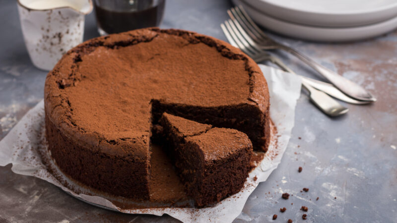 Flourless chocolate and espresso cake on concrete background