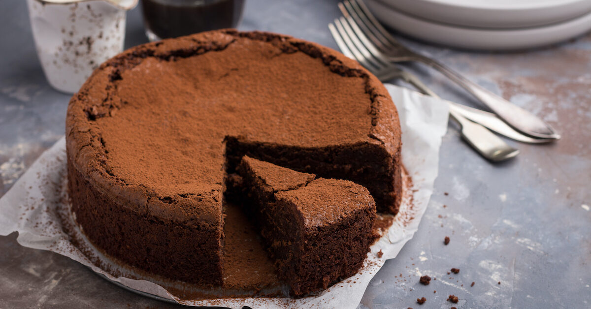 Flourless chocolate and espresso cake on concrete background