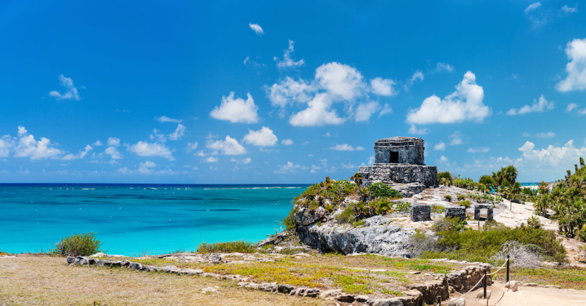 A large body of water with Tulum in the background