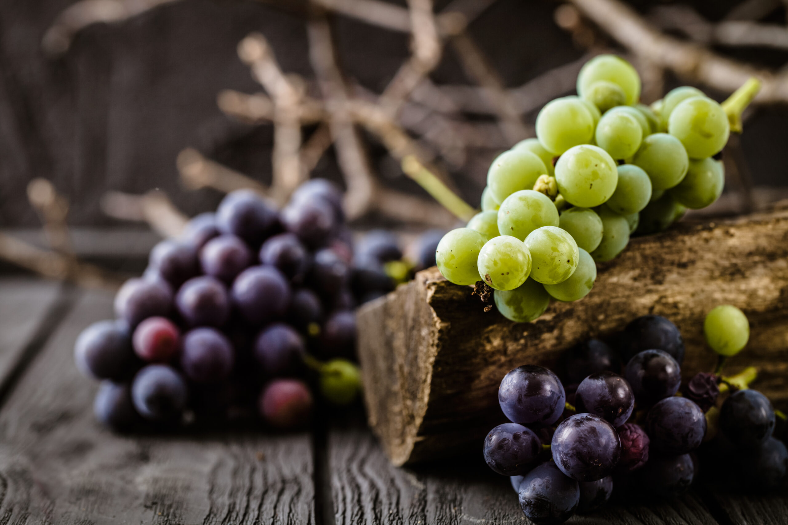 Grapes and a log on a wooden surface