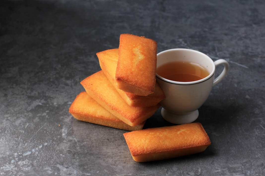 Delicious French Financiers Cake with Fresh Butter, Served with Tea. Copy Space for Text. On Grey Cement Background