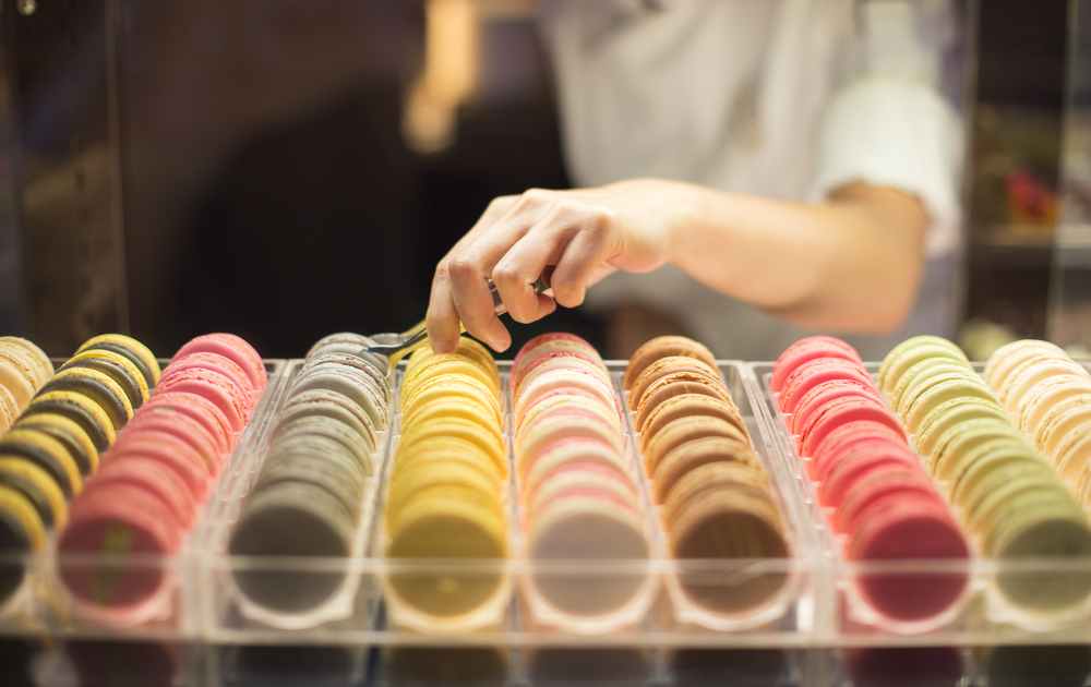 colorful macarons and a hand arranging them