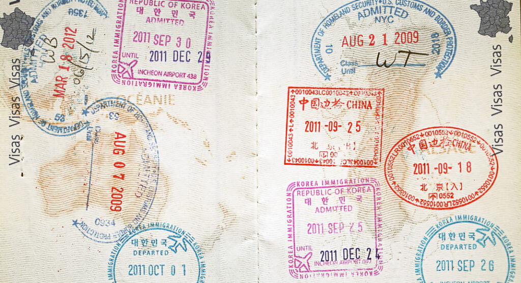 Inside a French passport with immigration stamps.