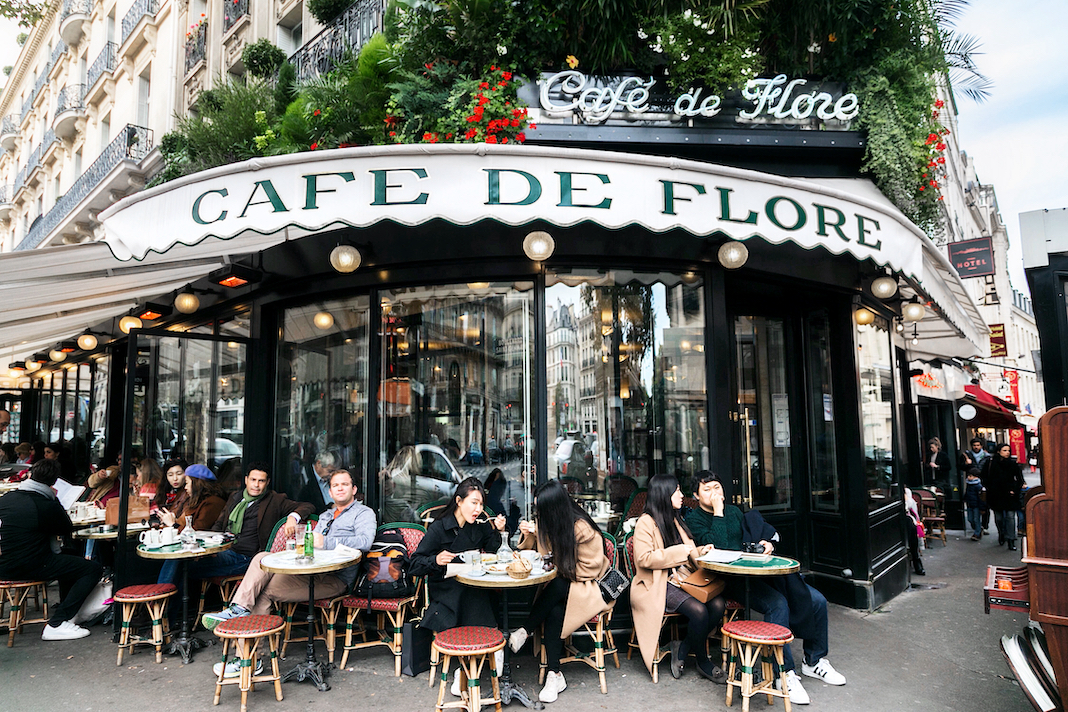 Paris, France - November 01, 2017: The famous Cafe de Flore and its visitors. Saint-Germain boulevard. Parisians and tourist enjoy eat and drinks in cafe sidewalk. Autumn Paris