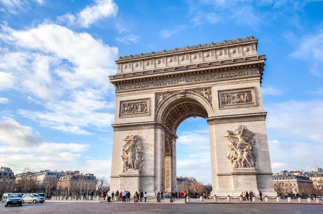 Famous Arc de Triomphe against nice blue sky Arc de Triomphe monument at at the western end of the Champs-elysees road in Paris, France