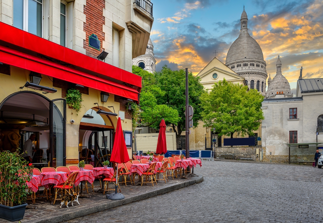 Cozy street with tables of cafe in Montmartre in Paris, France. Architecture and landmarks of Paris. Postcard of Paris
