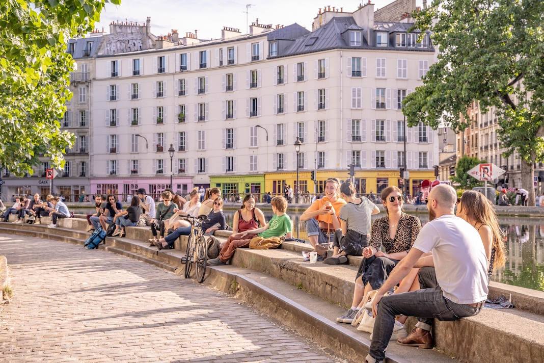 Paris, France - circa June 2022: People hang out along the canal in the Canal Saint Martin area.