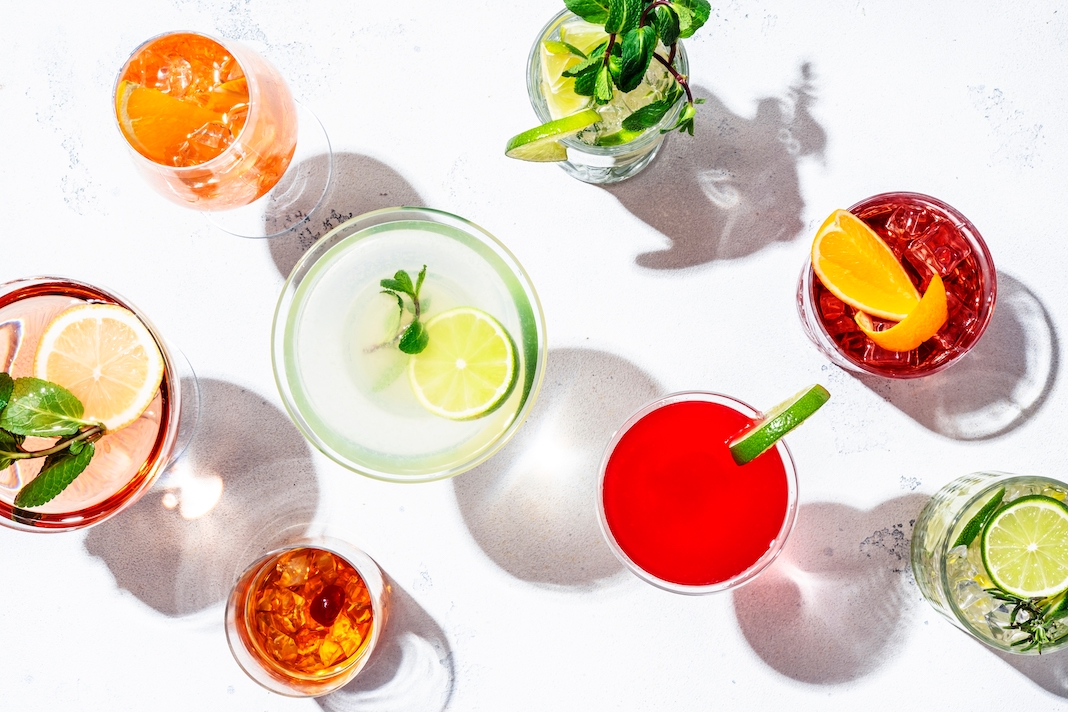 Most popular cocktails set: aperol spritz, negroni, mojito, gin tonic and cosmopolitan, daiquiri, margarita and old fashioned on white background, top view. Hard light